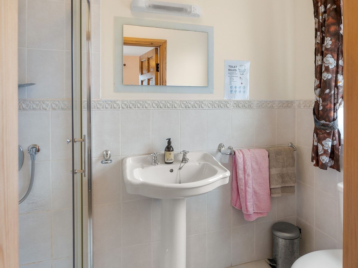 Un baño con ducha, lavamanos e inodoro.
