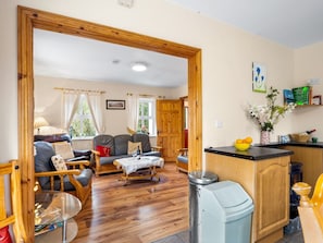 A cozy living room with a sofa, a coffee table, and a dining area with a counter.