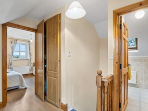 A room with a bed, a wooden door, and a light fixture. - Lough Mask Fishing Cottage (Ballinrobe)