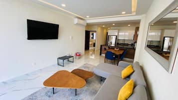 Departamento Deluxe, balcón, vista a la alberca | Sala de estar | Televisión de pantalla plana