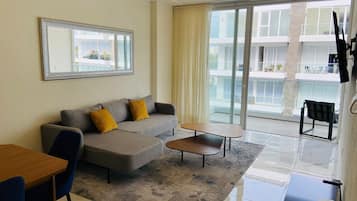 Departamento Deluxe, balcón, vista a la alberca | Sala de estar | Televisión de pantalla plana