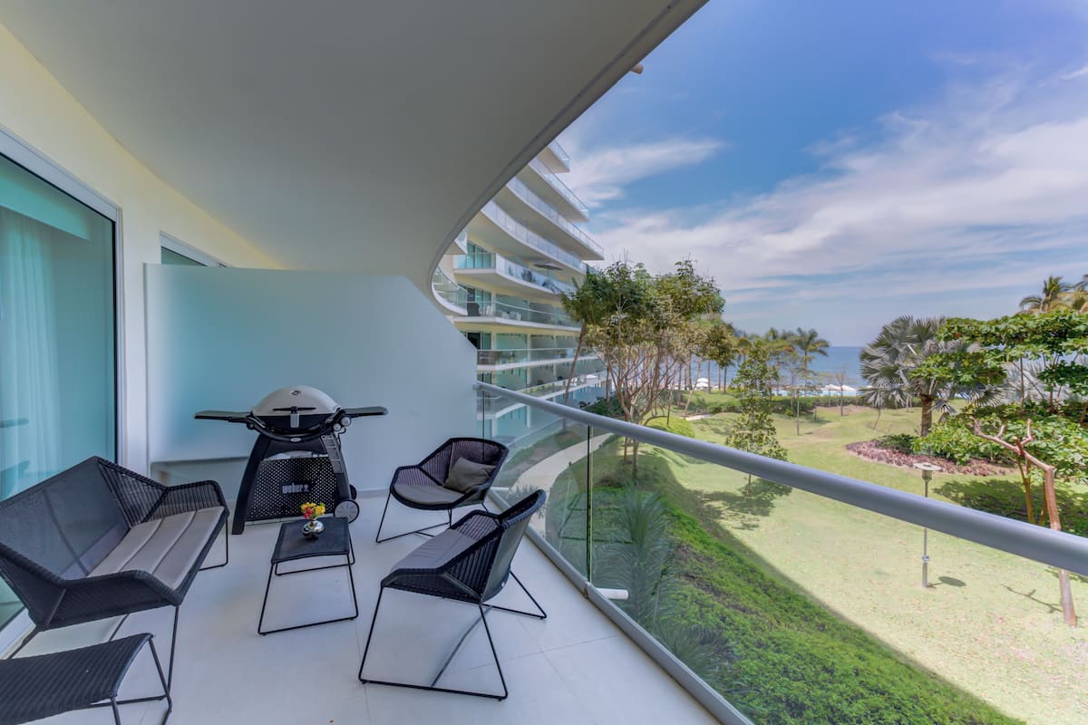 A balcony with a scooter, two chairs, and a table.