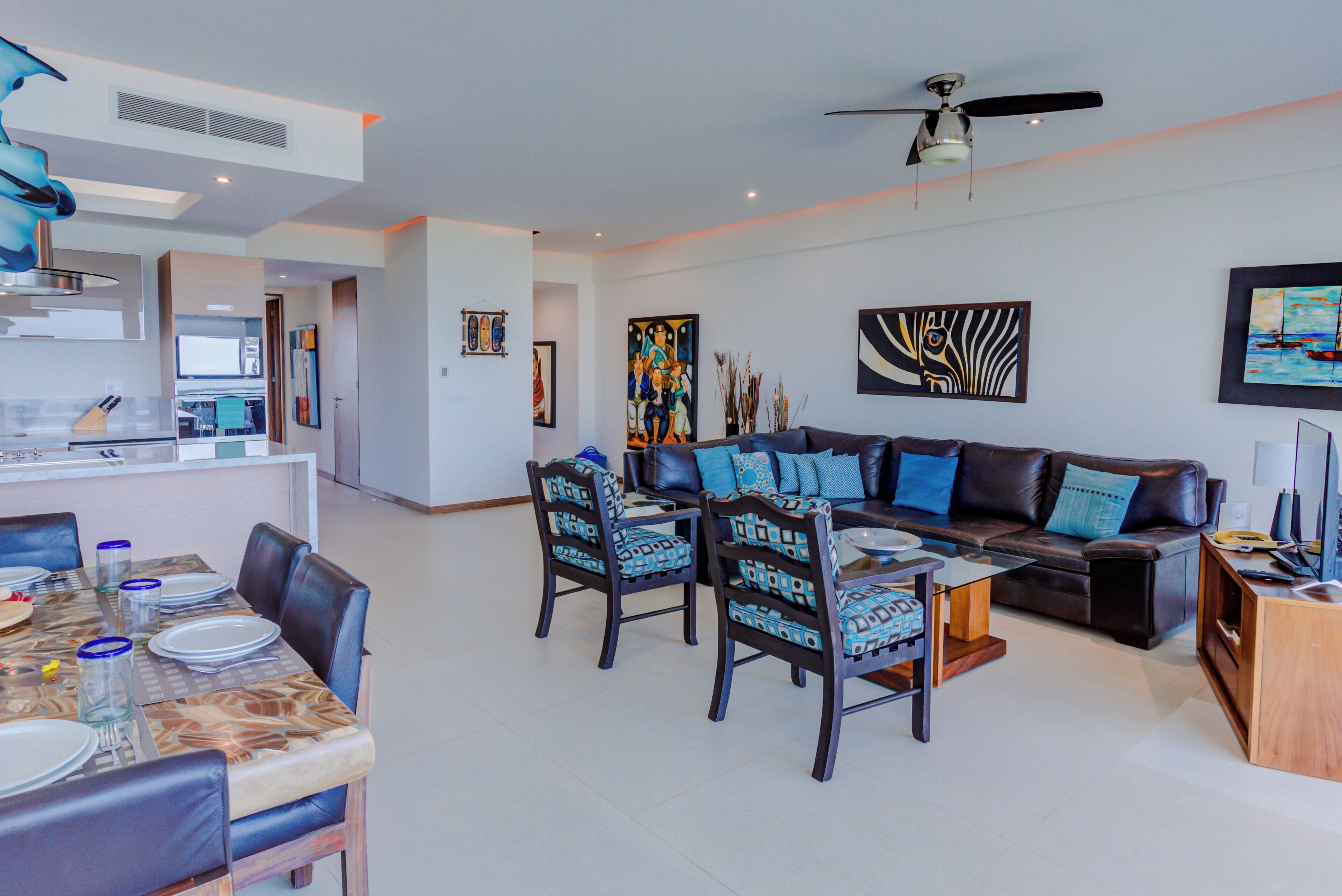Una sala de estar moderna con comedor, que incluye un sofá, sillas y una mesa de centro.