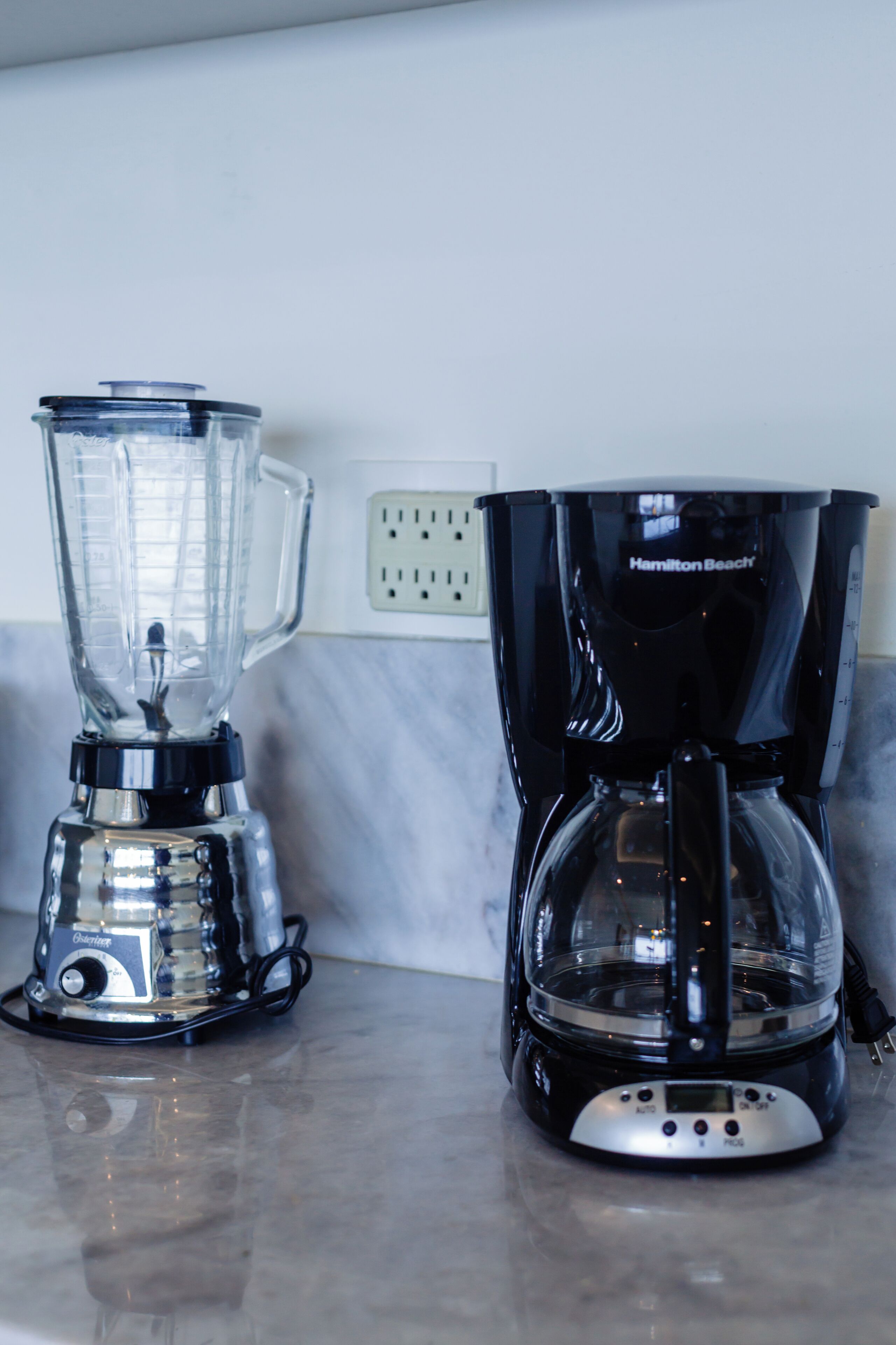 A kitchen with a blender and a coffee maker on the counter.