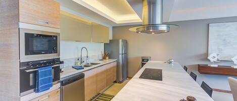 Una cucina moderna con elettrodomestici integrati, una grande isola e un elegante rivestimento.