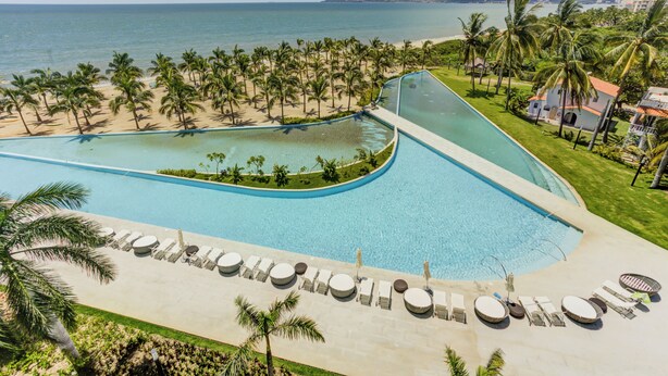 A resort with a large pool, palm trees, and a beach view. - Marítima Beachfront Playa Flamingos (Nuevo Nayarit)