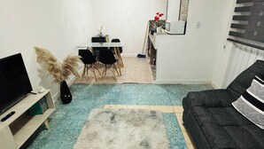 A living room with a sofa, a TV, a dining table with chairs, and a kitchen area in the background. - Safe and centrally located apartment (Ciudad de México)
