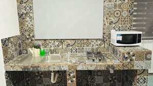 A kitchen with patterned tiles, a sink, a microwave, and a kettle. - Safe and centrally located apartment (Ciudad de México)