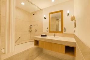 A modern bathroom with a bathtub, a sink with a mirror, and a shower area. - Hotel Luxe Stay (New Delhi)