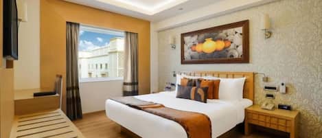 Una camera d'albergo con un letto, un comodino, una lampada e un quadro appeso al muro.