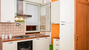 A compact kitchen with a gas stove, oven, and a window with blinds. - 2 bedroom beautiful apartment in Pozzallo (Pozzallo)