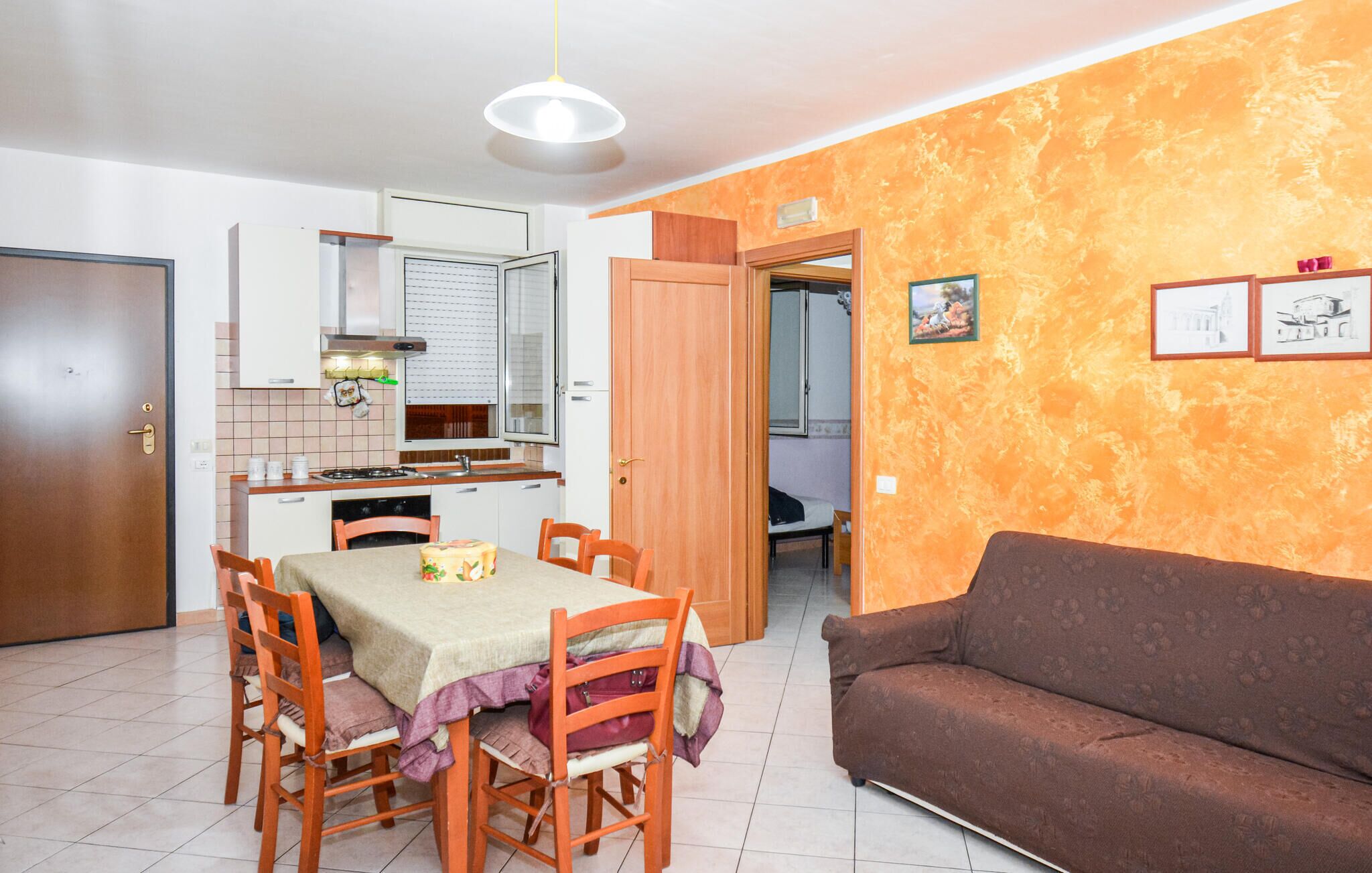 A compact living space with a dining area, kitchenette, and a sofa.