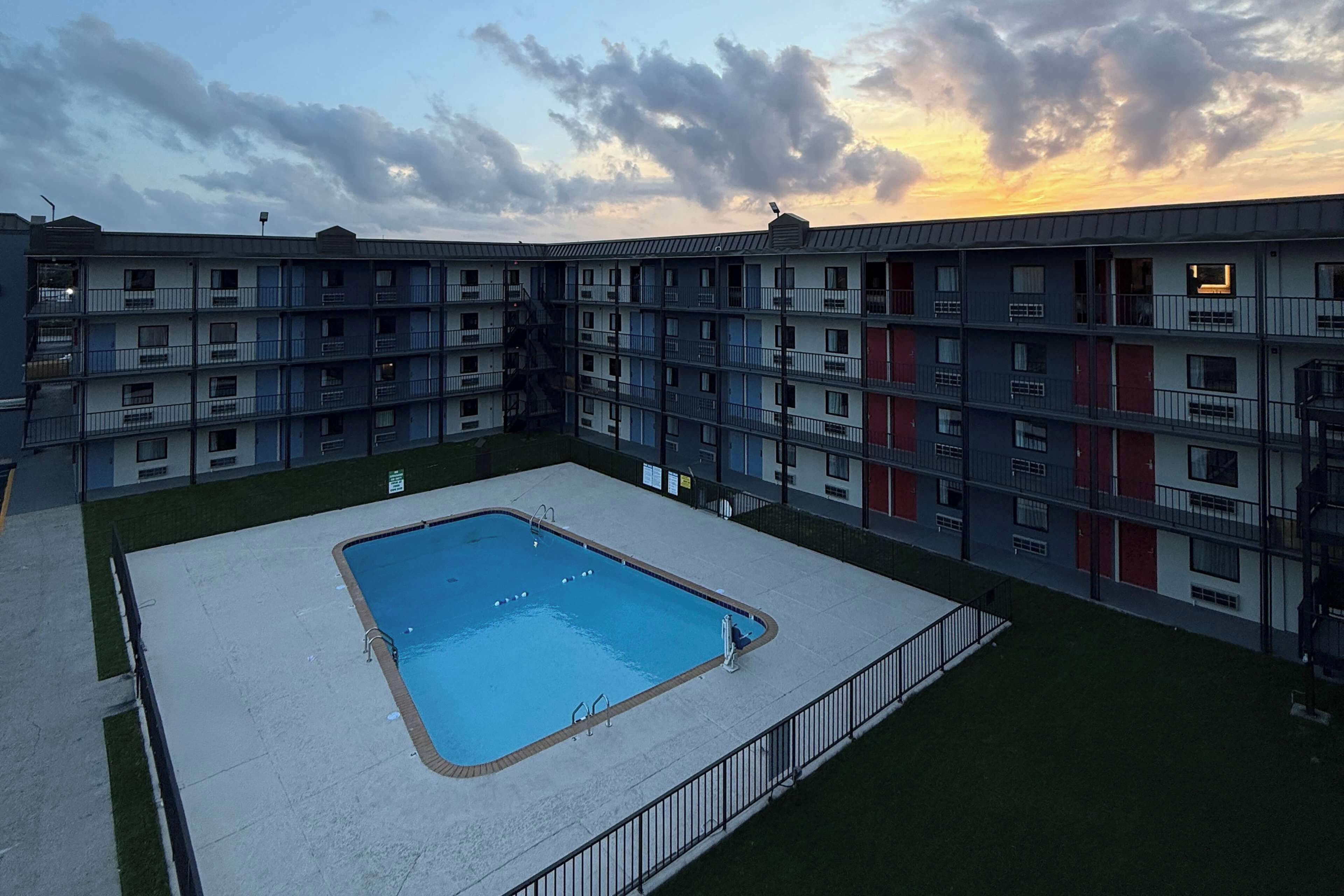 A multi-story residential building with a swimming pool in the courtyard.