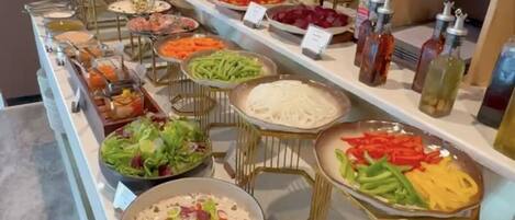 A buffet with various food items and condiments.