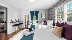 A hotel room with a bed, a vanity with mirrors, a bathroom, and a view of the outdoors. - 8 Beds, Large Groups, Karaoke, Firepit  (Charlotte)