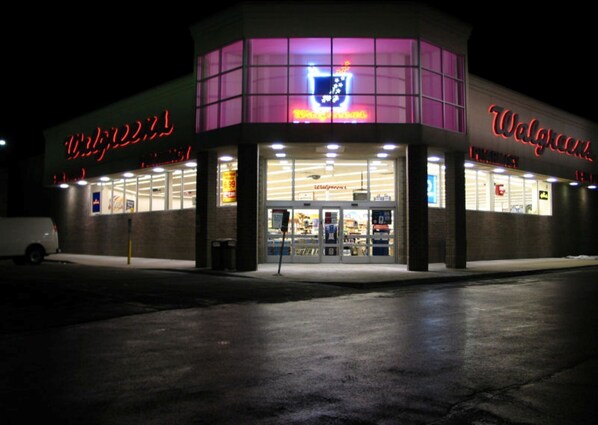 Una farmacia Walgreens de noche con señalización iluminada y entrada despejada.
