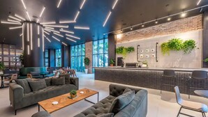 A modern lounge area with sofas, a coffee table, and a bar with plants. - Lux apartment in Miami downtown (Miami)