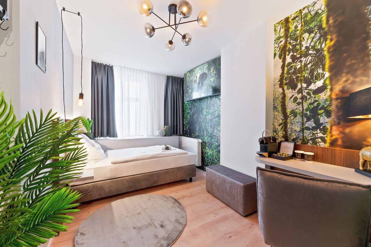 Une chambre moderne avec un lit, une table de chevet et une grande fenêtre avec des rideaux.