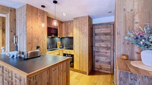 Een moderne keuken met houten kasten, een centraal eiland en hanglampen.