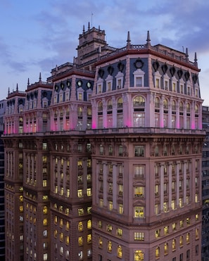 Um edifício de vários andares com arquitetura clássica, apresentando varandas elaboradas e grandes janelas.