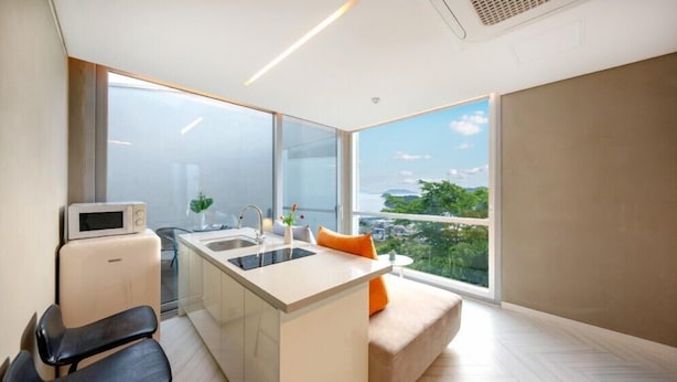 Una cocina moderna con estufa integrada, un lavamanos y un ventanal con vistas a la ciudad.