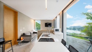 Una cocina moderna con estufa integrada, una mesa de comedor y un amplio ventanal con vistas panorámicas.
