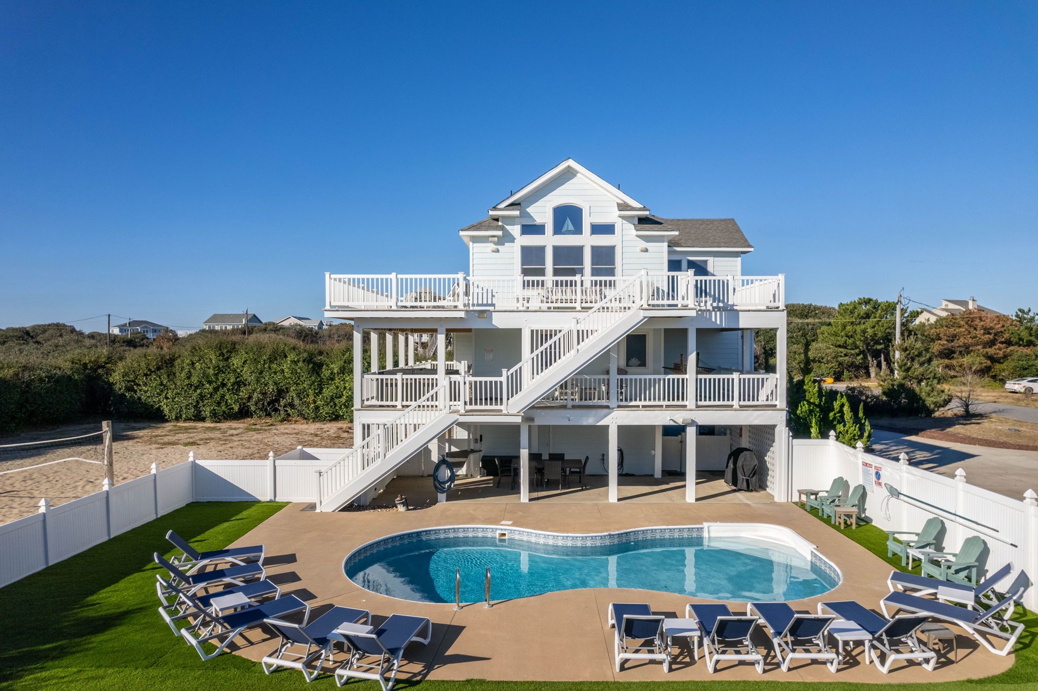A two-story building with a pool and outdoor seating.