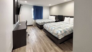 A modern hotel room with two beds, a desk, and a TV. - Studio 6 Sulphur, LA (Sulphur)