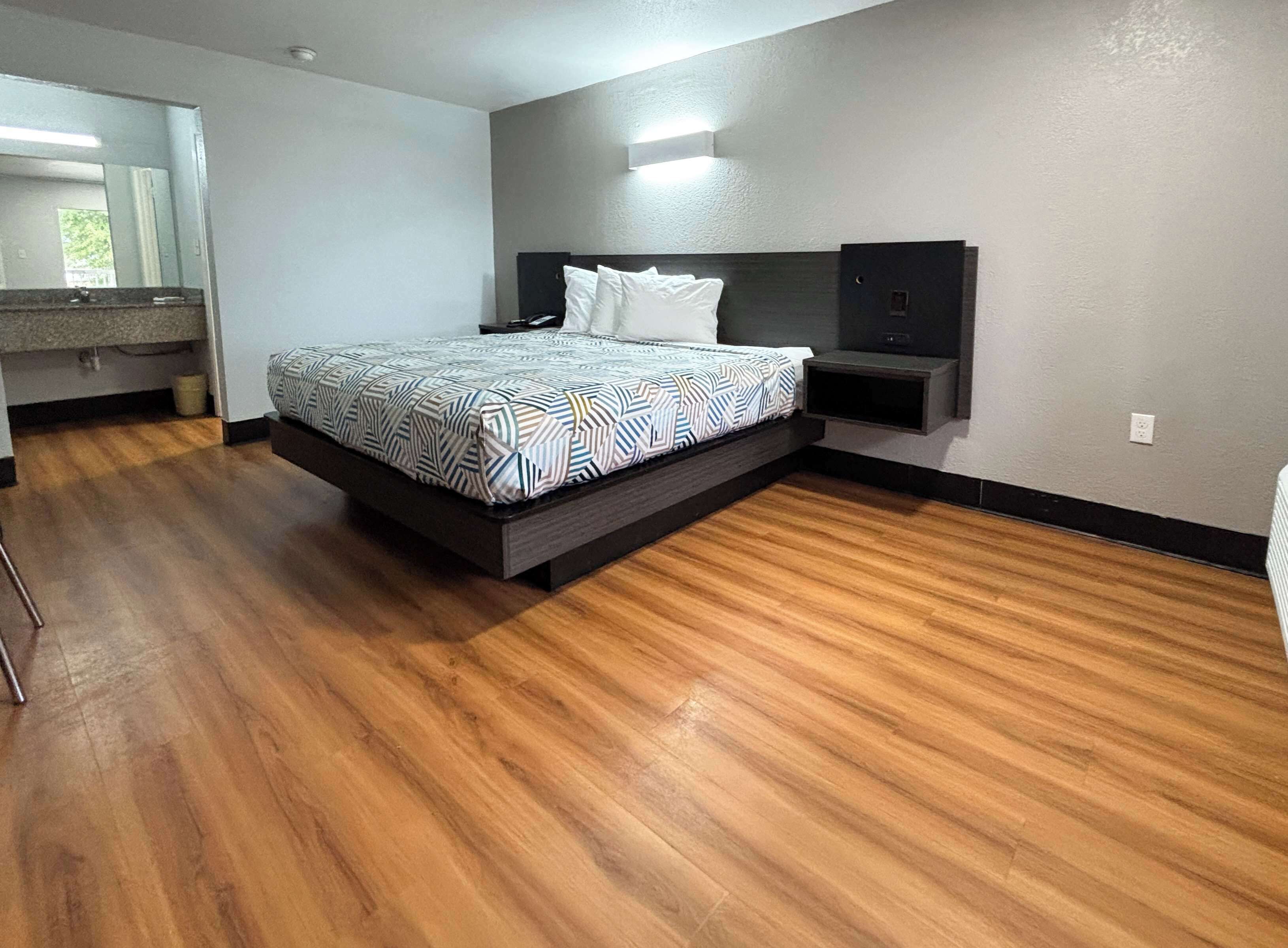 A modern bedroom with a bed, bedside table, and built-in TV.