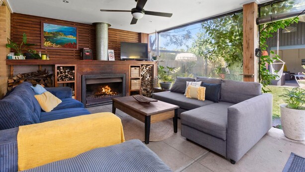 A modern living room with a fireplace, sofas, and a television. - The Beach Barn - Balnarring Beach (Balnarring Beach)