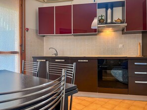Une cuisine moderne avec un coin repas, comprenant un évier, une cuisinière et des placards.