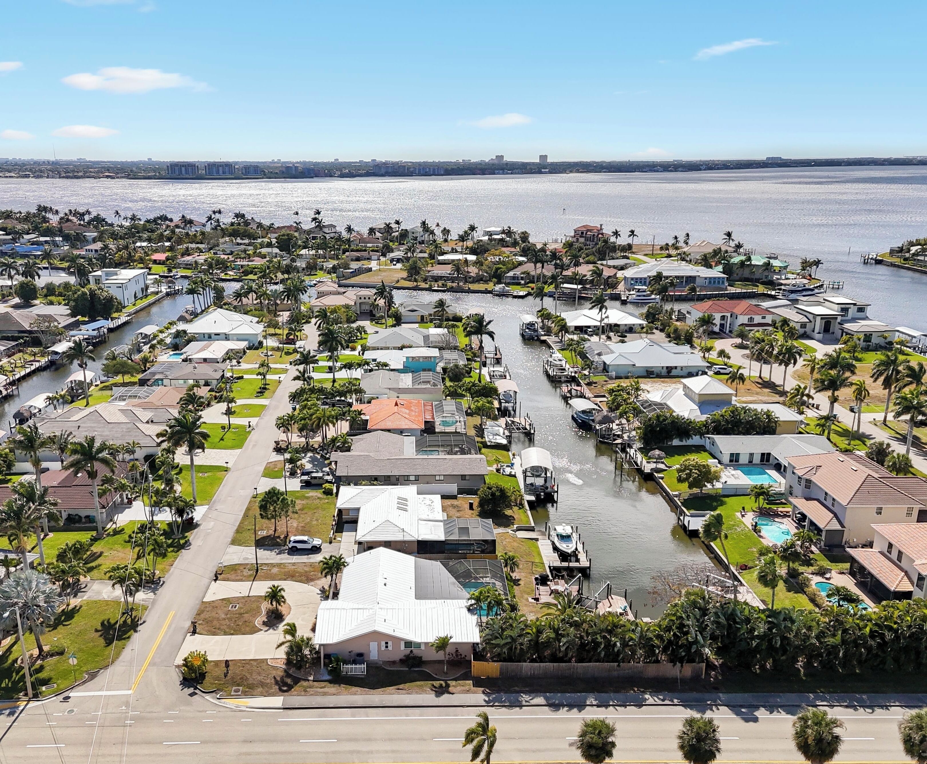 Un quartier résidentiel comprenant des maisons, un port de plaisance et une vaste étendue d’eau.