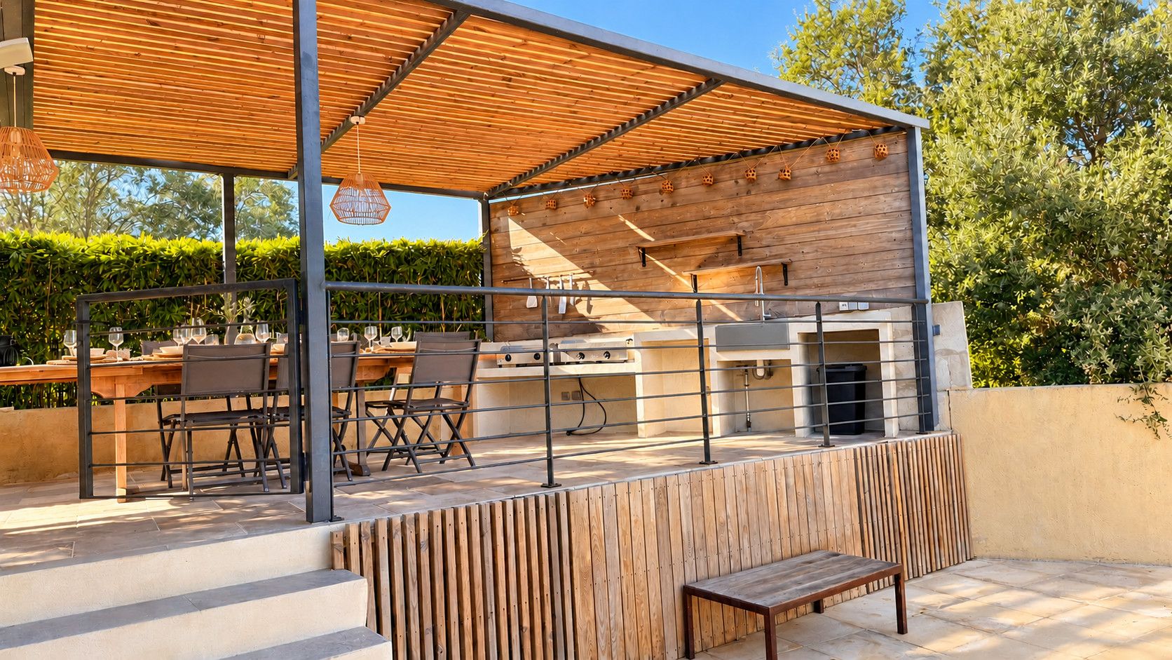 An outdoor patio with a wooden table and chairs, a grill, and a wooden bench.