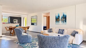 A modern living room with a sofa, chairs, and a dining area with a table and chairs. - Villa Mathilda Di Porto-Vecchio (Porto-Vecchio)