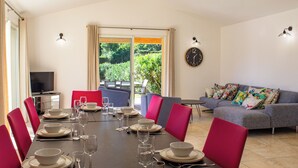 Un coin repas avec une table mise pour le repas, un canapé et un téléviseur en arrière-plan.