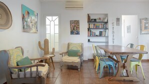 Un comedor con una mesa de madera, sillas y una estantería.