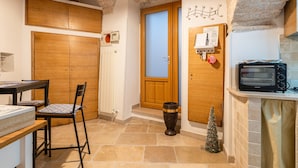 A kitchen with a microwave, a small Christmas tree, and a wooden cabinet.