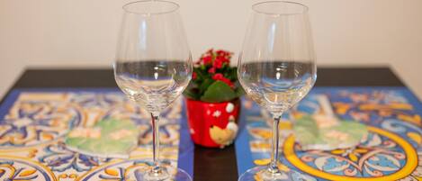 Two empty wine glasses on a table with a colorful patterned tablecloth.