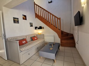 Un saló amb un sofà, una taula de centre i una escala.