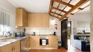 Eine moderne Küche mit Holzausstattung, einem eingebauten Backofen und einer Kaffeemaschine.