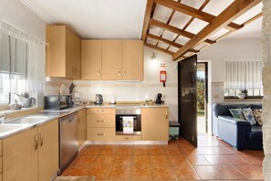 A modern kitchen with wooden cabinets, a built-in oven, and a coffee maker.
