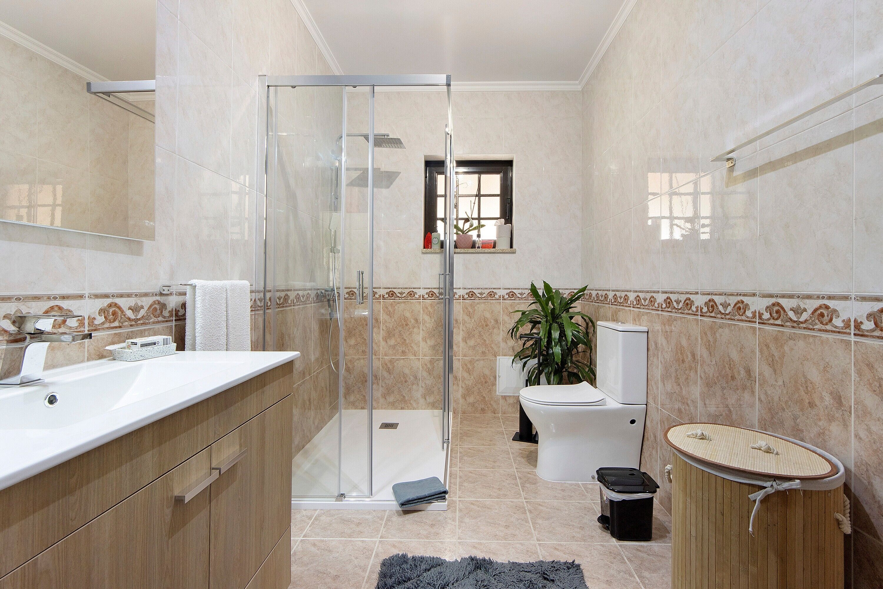 A bathroom with a glass shower enclosure, a toilet, a sink, and a bidet.