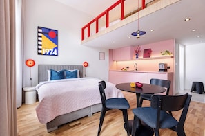 A modern hotel room with a bed, a dining table, chairs, a kitchenette, and a loft area. - TurnKey | Wenceslas sq. 2-level apt. w/ balcony II (Praha 1)