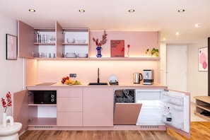 A modern kitchen with built-in appliances, a sink, and a countertop with a kettle and fruit. - TurnKey | Wenceslas sq. 2-level apt. w/ balcony II (Praha 1)