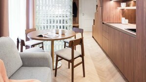 Un intérieur moderne comprenant un espace repas, une cuisine et une chambre à coucher située en mezzanine.