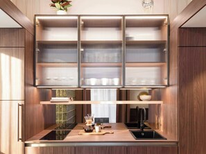 A modern kitchen with built-in cabinets, a coffee maker, and a sleek countertop. - TurnKey | Wenceslas square Two Level Apartment XI (Praha 1)