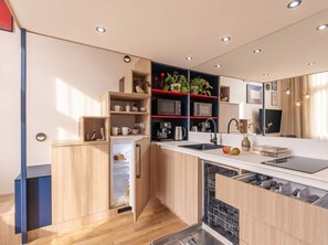 A modern kitchen with built-in appliances, wooden cabinetry, and a dishwasher.
