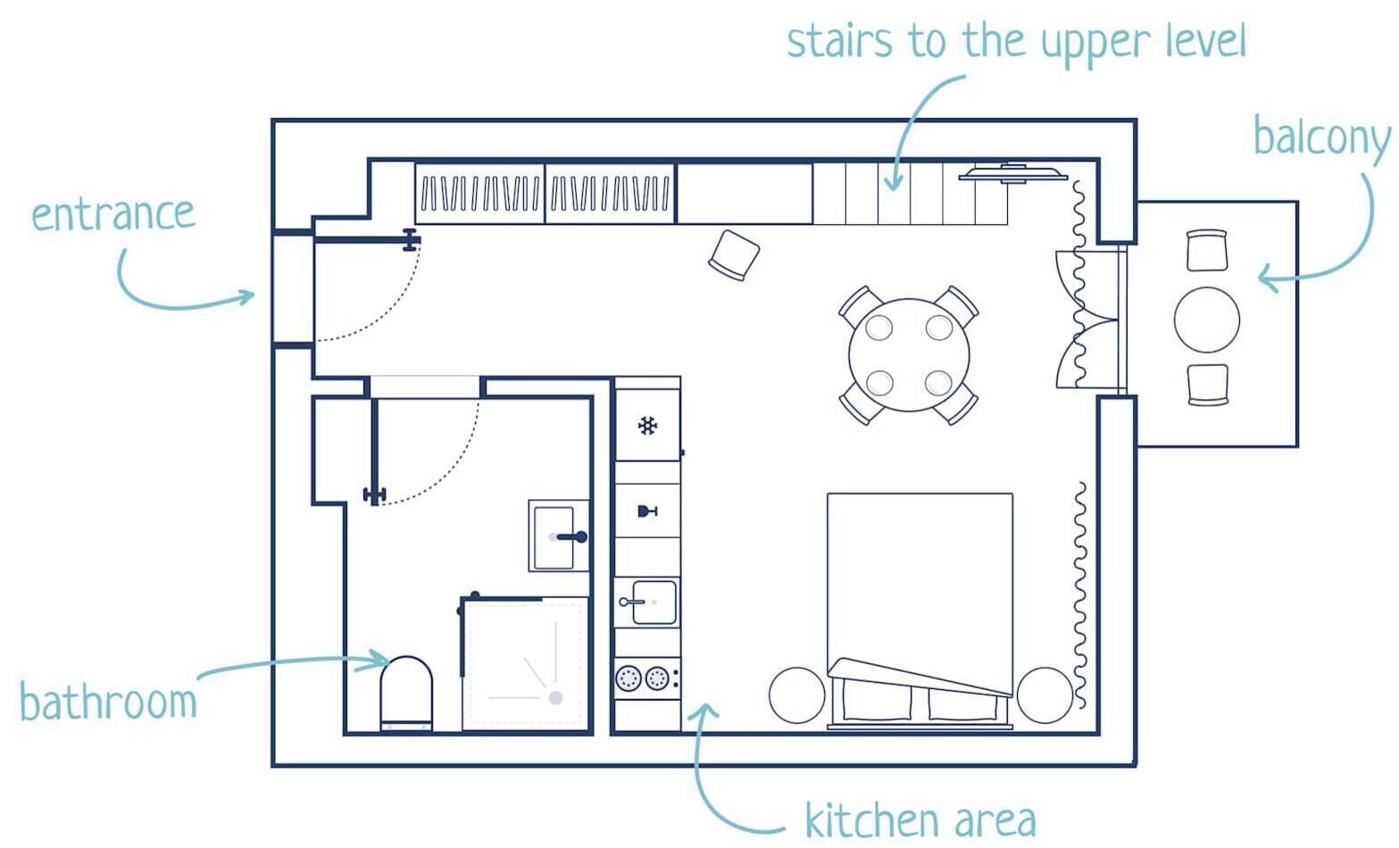 A floor plan with an entrance, bathroom, kitchen area, upper level stairs, and a balcony.