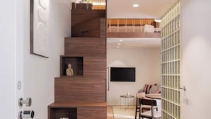 A modern staircase with wooden steps and built-in shelves, leading to a dining area with a table and chairs. - TurnKey| Wenceslas square Two Level Apartment XIII (Praha 1)