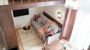 A modern hotel room with a bed, sofa, and a small dining area. - TurnKey| Wenceslas square Two Level Apartment XIII (Praha 1)
